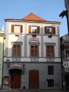 a white building with red doors and windows at Ubytování u BÍLÉ PANÍ in Český Krumlov