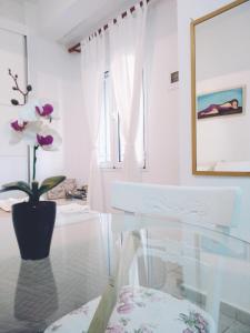 a dining room with a glass table and a vase with flowers at Polymnia's apartment in Matala