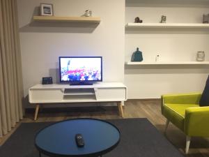 a living room with a tv on a white cabinet at Apartamento da Seara "Douro" in Lamego