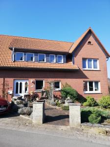 une maison en briques rouges avec un toit rouge dans l'établissement Wintergarten am Thingplatz, à Rinteln