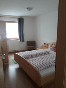 a bedroom with a large bed with a window at Hofstatthof in Campo di Trens