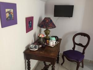 a small table with a lamp and a chair at La Jourdane in Saint-Alexandre