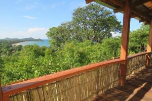 a wooden porch with a view of the water at Gateway Guest House in Monkey Bay