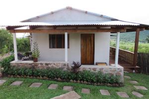 a small white house with a wooden door at Gateway Guest House in Monkey Bay