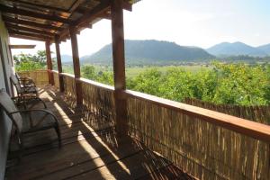 a porch with chairs and a view of the mountains at Gateway Guest House in Monkey Bay