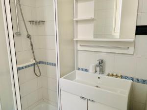 a white bathroom with a sink and a shower at Front Lake Apartment Bardolino in Bardolino