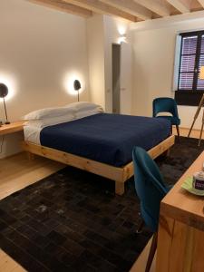 a bedroom with a bed and a desk and chairs at Ca'Bert Villa dei Glicini in Castelnuovo del Garda