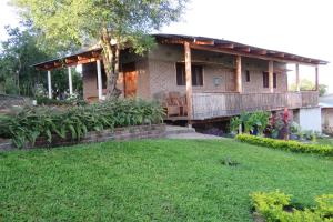 a house with a deck and a yard at Gateway Guest House in Monkey Bay