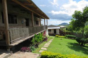 a house with a yard with grass and flowers at Gateway Guest House in Monkey Bay