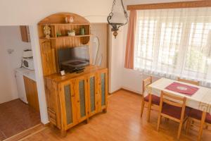 a living room with a television on a wooden entertainment center at Casa Kelemen in Sovata