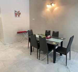 a dining room with a table and black chairs at AK Homestay in Port Dickson