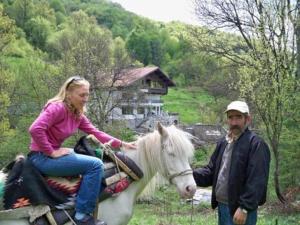 Eine Frau, die auf einem Pferd neben einem Mann reitet. in der Unterkunft Villa Cherven in Tetewen