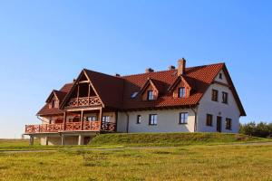 een groot huis bovenop een grasheuvel bij Apartamenty U Bandurskich in Sikorzyno