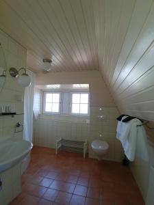 a bathroom with a toilet, sink, tub and window at Hotel Het Gouden Boltje in De Koog