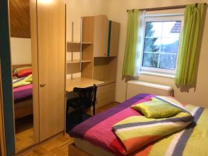 ArnfelsにあるFerienwohnung Peklarのベッドルーム1室(ベッド1台、デスク、窓付)