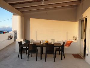 a dining room with a table and chairs on a balcony at La Campanella Lipari in Acquacalda