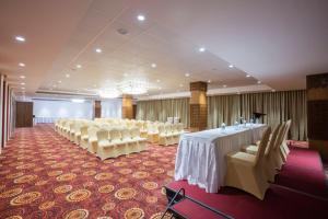 a banquet hall with white tables and white chairs at Sapphire Premium Hotel & Suite in Karād