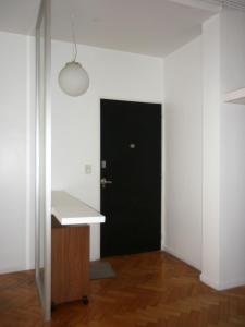 a hallway with a black door in a white room at Excelente departamento en Retiro in Buenos Aires