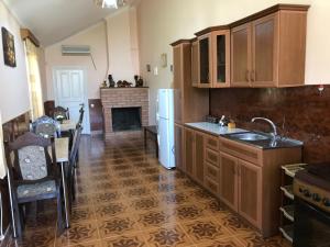 a kitchen with wooden cabinets and a fireplace at Sweet Memories in Kutaisi