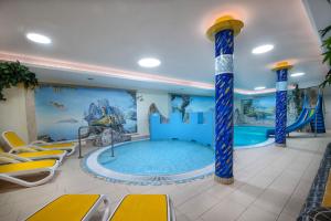 una piscina in una camera d'albergo con scivolo d'acqua di Hotel Zauchensee Zentral a Zauchensee
