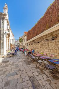 a group of tables and chairs on a stone street at Apartments Feri in Dubrovnik