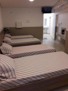 3 lits sont disposés dans une pièce dans l'établissement Hotel YES (Adult Only), à São Paulo