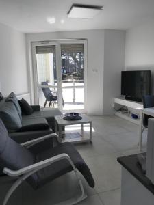 a living room with a couch and a tv at Apartament bursztynowy in Jantar
