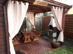 patio z drewnianą pergolą i sprzętem do grillowania w obiekcie Tajek w Stegnie