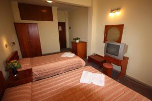 pokój hotelowy z dwoma łóżkami i telewizorem w obiekcie Cavo D' Oro w mieście Nea Moudania