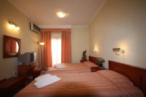 pokój hotelowy z dwoma łóżkami i telewizorem w obiekcie Cavo D' Oro w mieście Nea Moudania