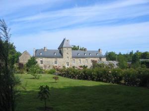 un grand château dans un champ d'herbe verdoyante dans l'établissement Chambres d'hôtes Château de Bonabry, à Hillion