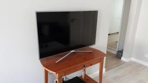duży telewizor z płaskim ekranem na drewnianym stole w obiekcie Apartament Paderewskiego 11 w Świnoujściu
