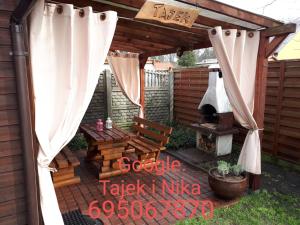 patio z drewnianą pergolą i sprzętem do grillowania w obiekcie Tajek w Stegnie