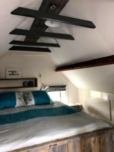 1 dormitorio con 1 cama grande en una habitación con vigas de madera en Bloemenboerderij Aperloo en Aperloo