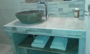 Menelaos Apartments في ليفوكاسترو: حمام مع حوض ووعاء على منضدة