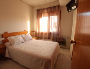 a bedroom with a white bed and a window at Hostal Sierra de Gredos in Arenas de San Pedro +10 photos