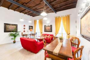 a living room with red chairs and a wooden table at Sistina House Style HolidayHome x 6 in Rome