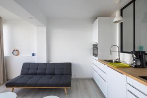 a living room with a couch in a kitchen at Ker Romain - Studio - Vue Mer 180 degres in Saint Malo