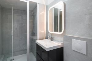 a bathroom with a sink and a mirror and a shower at Ker Romain - Studio - Vue Mer 180 degres in Saint Malo