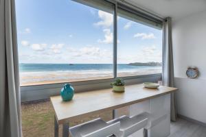 a room with a table and a large window with the ocean at Ker Romain - Studio - Vue Mer 180 degres in Saint Malo
