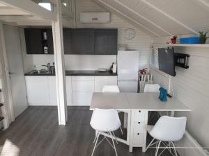 a kitchen with a white table and white chairs at Cozy Cabin in Čatež ob Savi