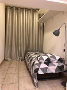 a bedroom with a bed with a lamp and a curtain at VVA in Conques-sur-Orbiel