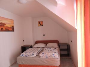 Dormitorio pequeño con cama en el ático en Apartments Gubanec, en Cerklje na Gorenjskem