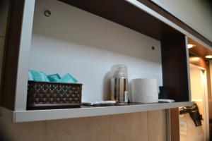 estante en el baño con una cesta de papel higiénico en Selknam en Ushuaia