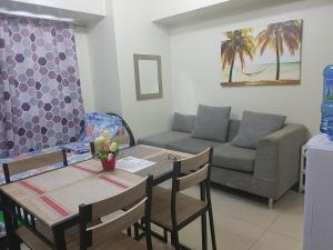 een woonkamer met een tafel en een bank bij KC 1-Bedroom 1 at Horizon 101 Cebu in Cebu City