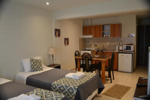 a hotel room with two beds and a kitchen at Selknam in Ushuaia