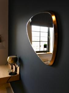 a round mirror on a wall in a room at Urban Nest in Huy