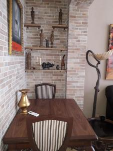 a wooden table with two chairs and a brick wall at Carrer Roma in Sagunto