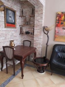 een woonkamer met een tafel en stoelen en een bakstenen muur bij Carrer Roma in Sagunto