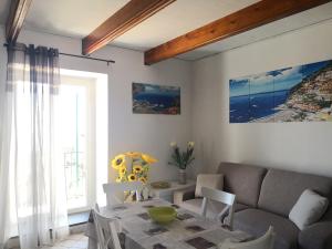 uma sala de estar com uma mesa e um sofá em Il Quadrifoglio em Massa Lubrense